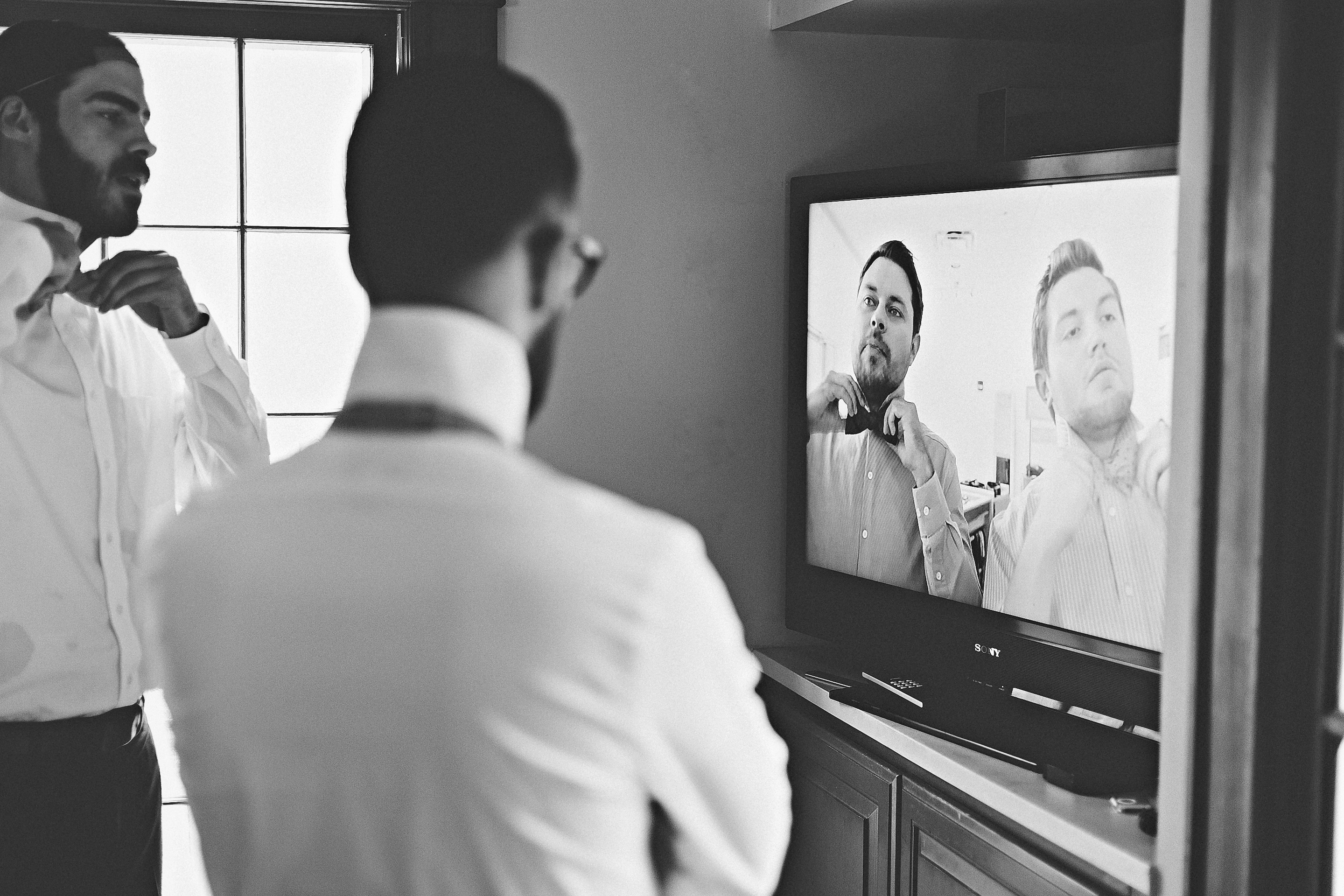 groomsmen watching youtube on how to tie a bow tie. bow tie. how to